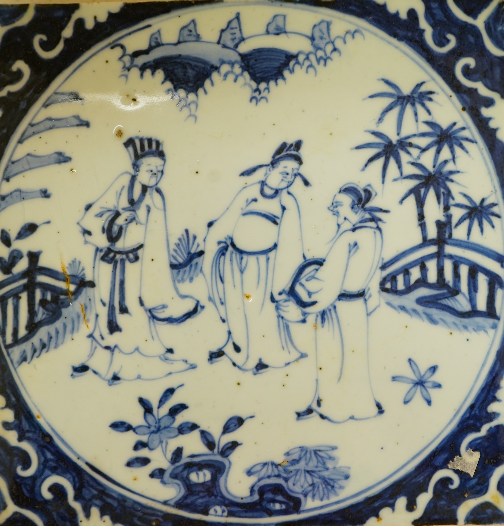 A Chinese tile depicting three figures, 20cm wide
